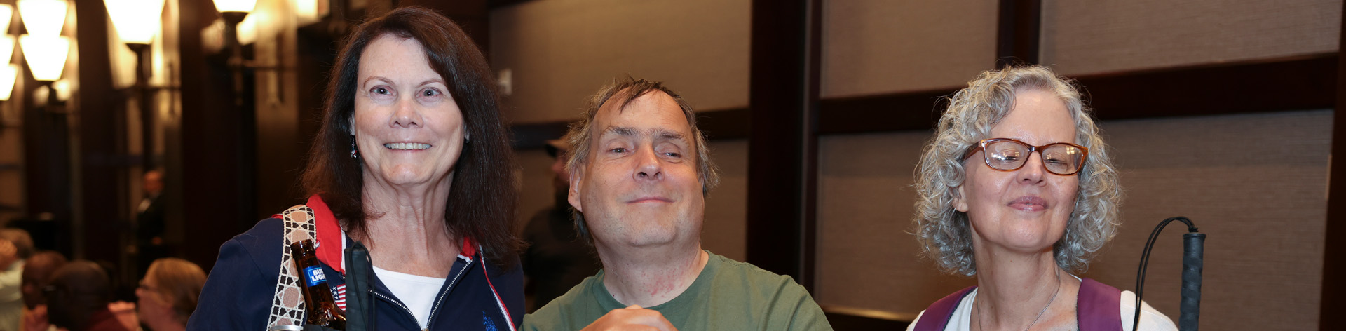 Three NFB of Connecticut members smile together.